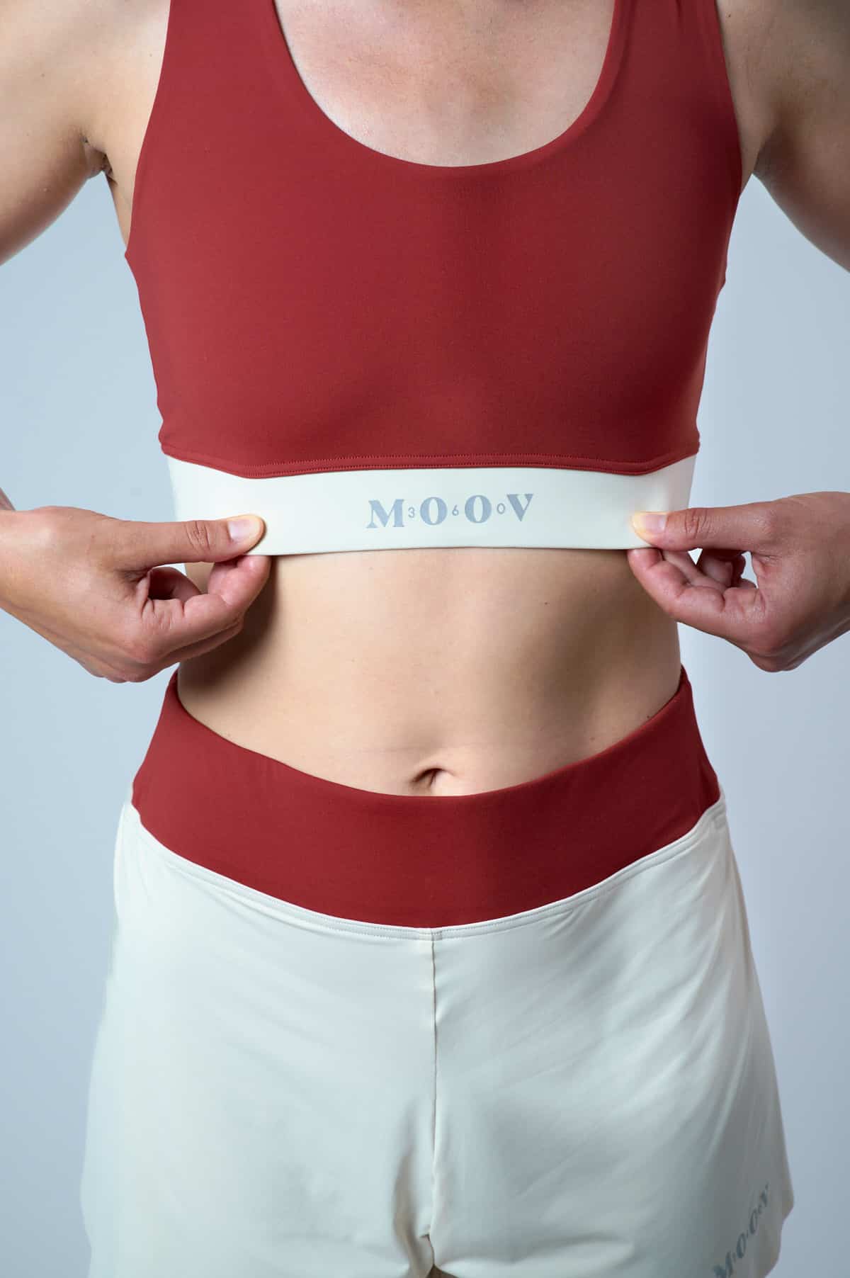 Brassière sport Cortina TERRA Moov360 en nylon régénéré ECONYL rouge terracotta portée de face, bande élastique MOOV, maintien optimal pour trail running
