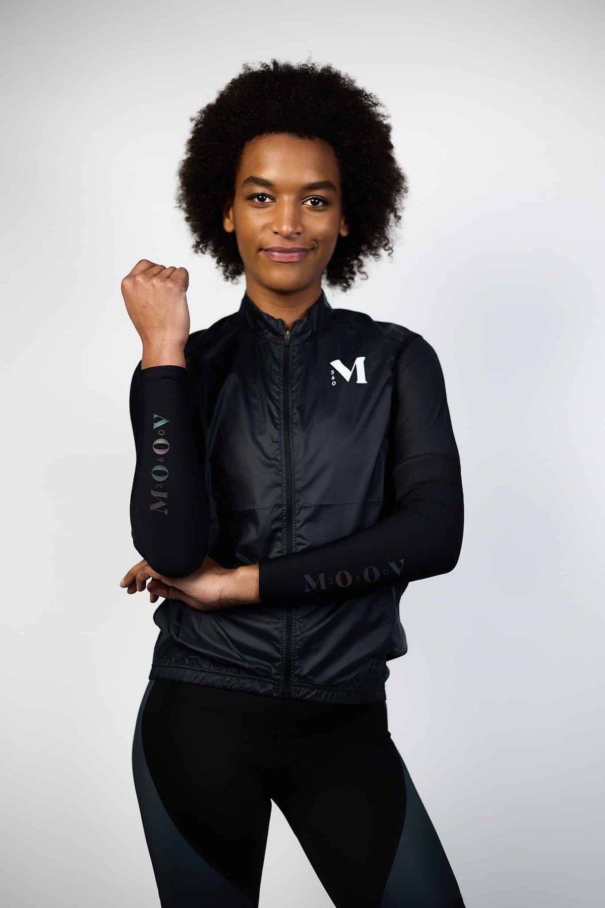 Manchettes OOrizon Moov360 noires portées par une femme, manchettes compressives avec logo MOOV pour running et trail