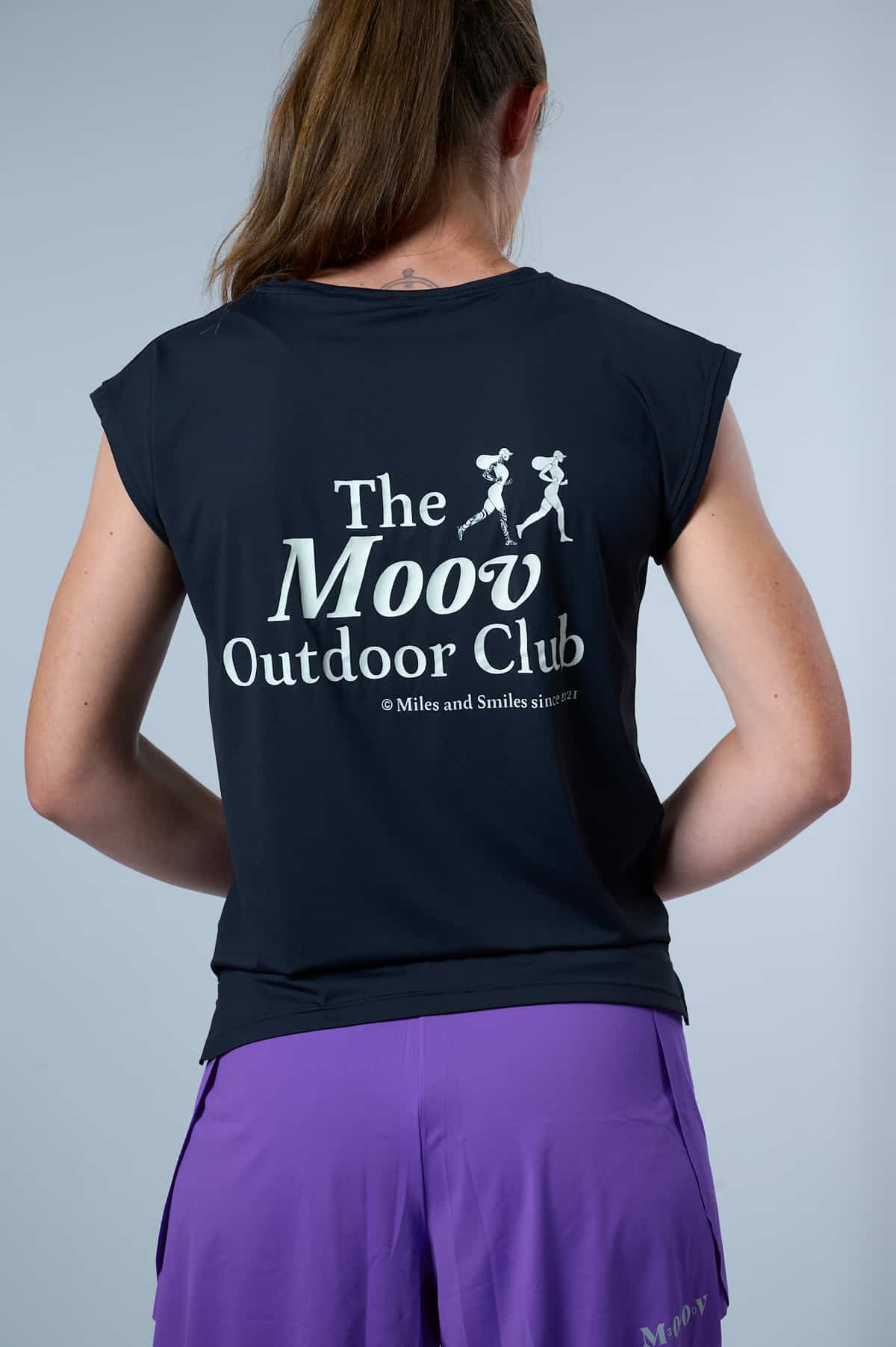 T-shirt Ultra Dry The Moov Outdoor Club Moov360 bleu marine porté par une femme vue de dos, logo imprimé, tissu ECONYL séchage rapide, coupe féminine trail running