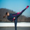 Woman performing a karate kick wearing sustainable sportswear by Moov360