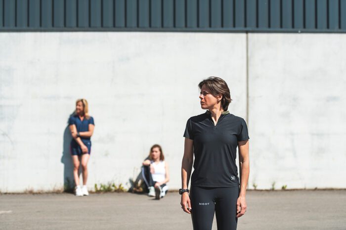 Woman in front of a factory wearing Moov360 eco-friendly sportswear Black - Khaki